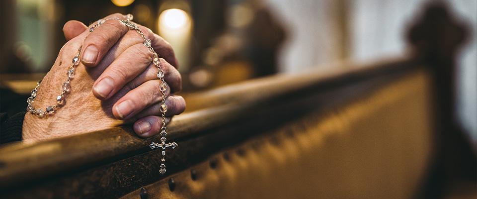 Ręce złożone do modlitwy trzymające różaniec